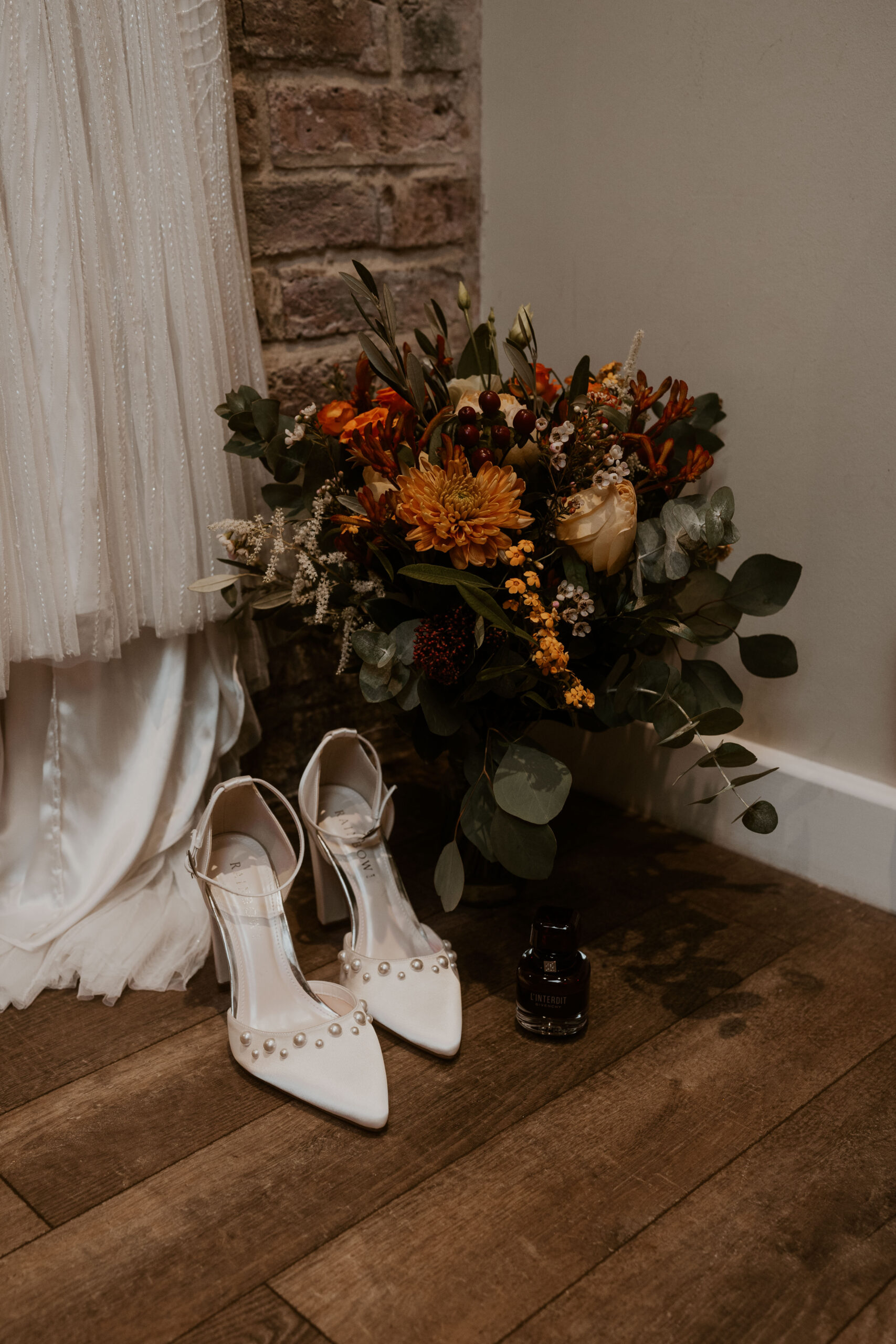 Relaxed wedding photographer capturing Brides wedding bouquet and rainbow heels