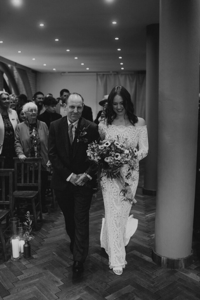 Bride And Dad Walking Down Isle in Wedding Ceremony at The Pumping House, Ollerton. Wedding Photographer