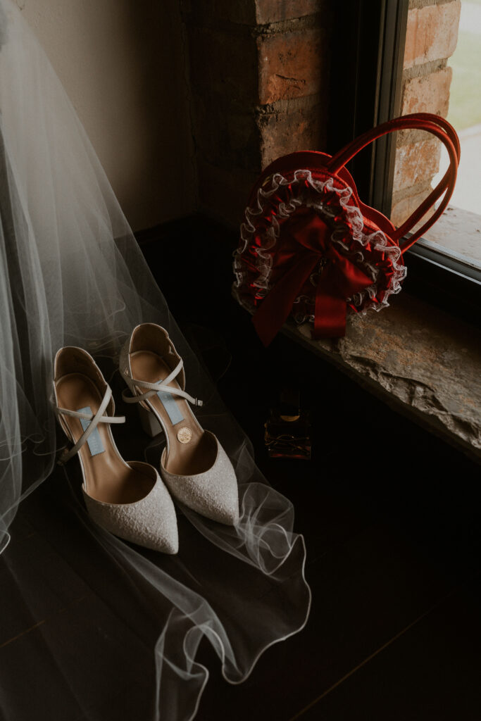 Alternative brides wedding shoes by Charlotte Mills and wedding accessories captured by the window Willow Marsh Farm 
