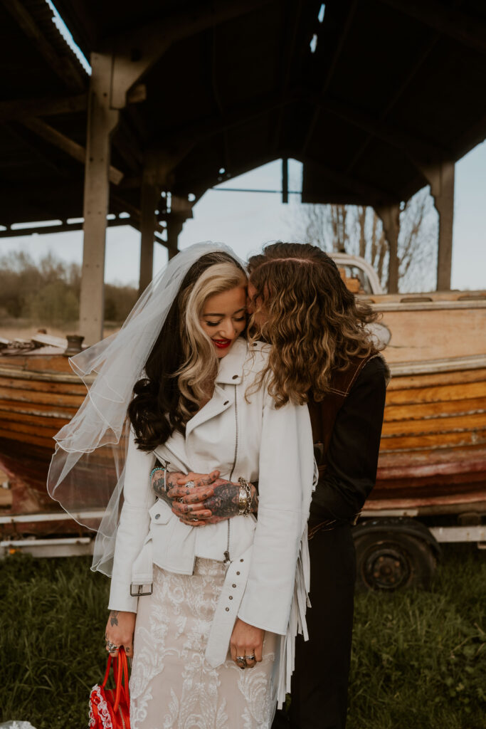 Newly married couple, adventurous and wild at heart, embarking on their next great adventure together, kissing at willow marsh farm