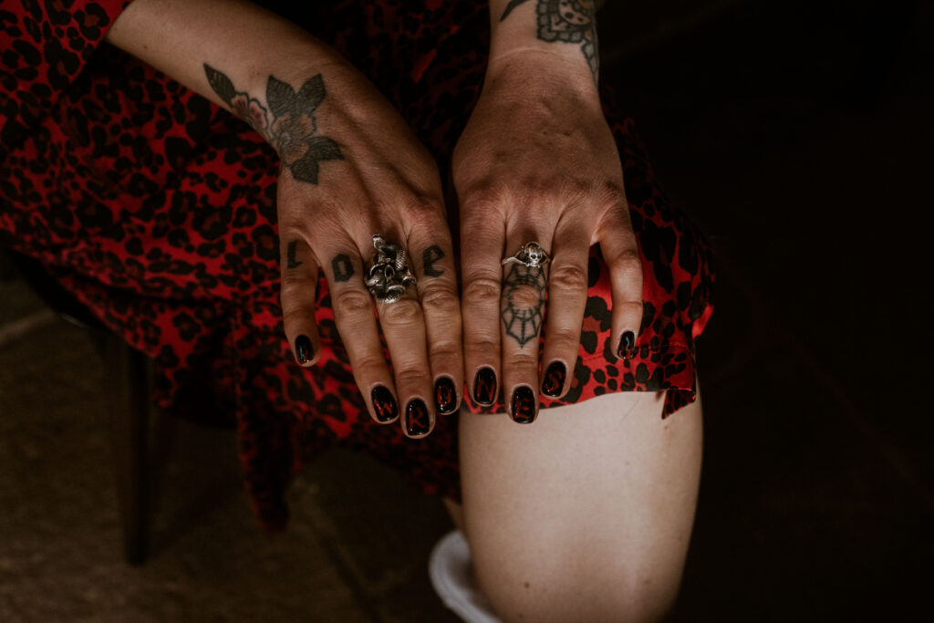 Alternative bride showing off her cool tattooed hands and nails at Willow Marsh Farm captured by a relaxed wedding photographer