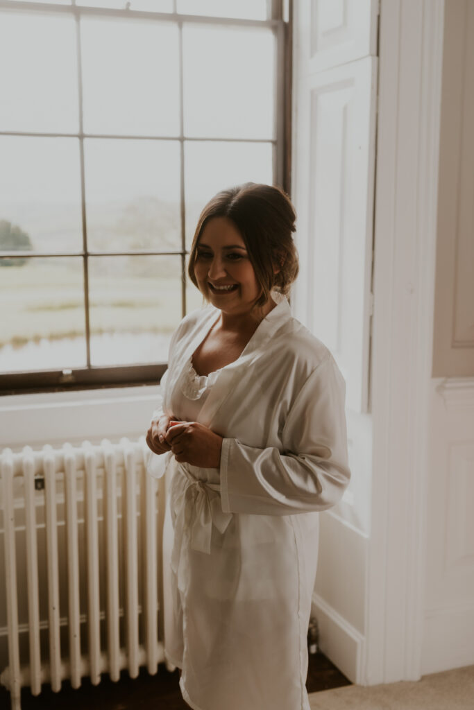 bride smiling during her wedding morning prep celebrating with bridal party at Davenport House 
