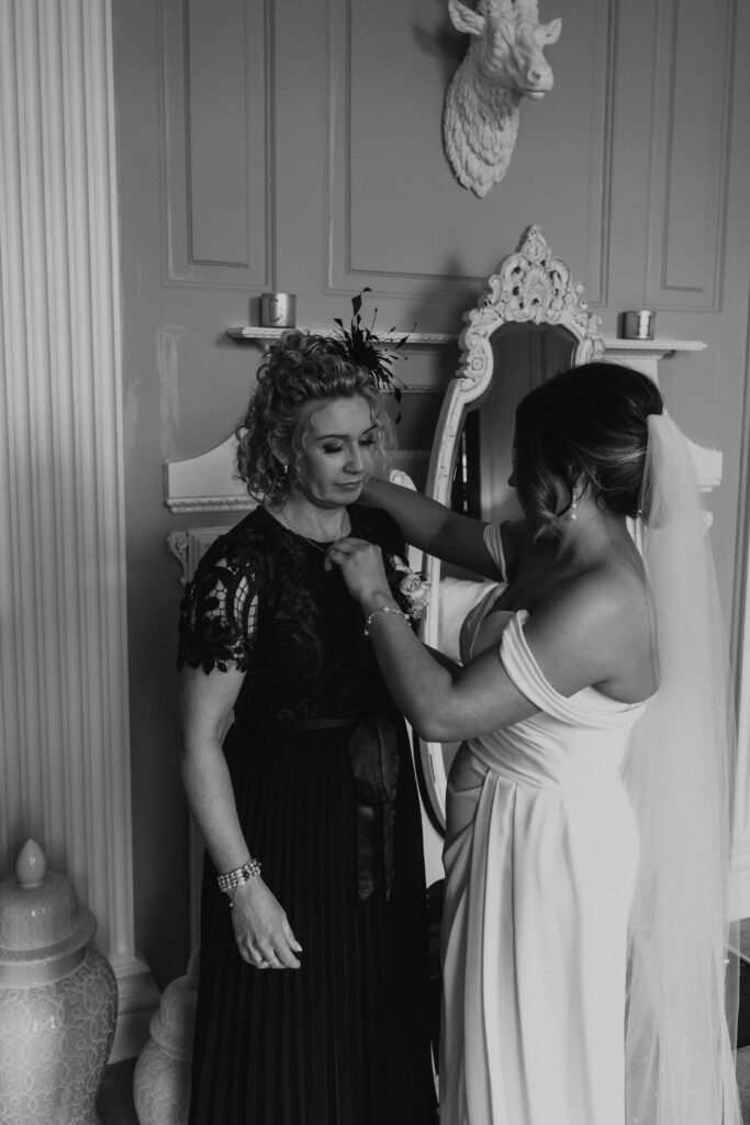 wedding black and white photo of bride getting ready with her finishing touches at davenport house 