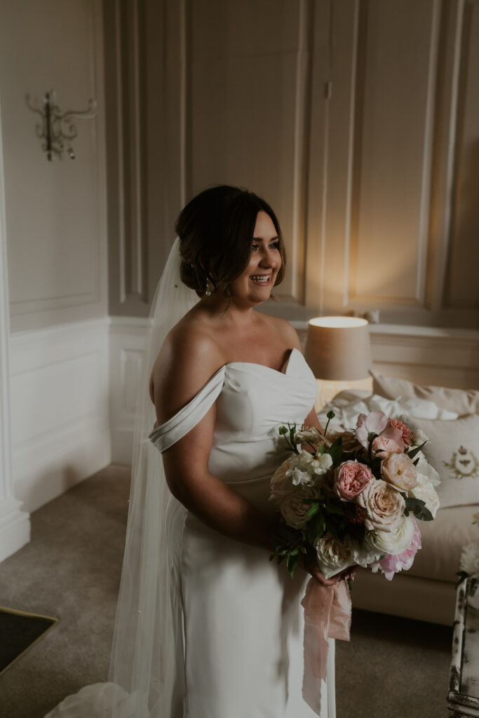 wedding photo of bride getting ready with her finishing touches at davenport house 