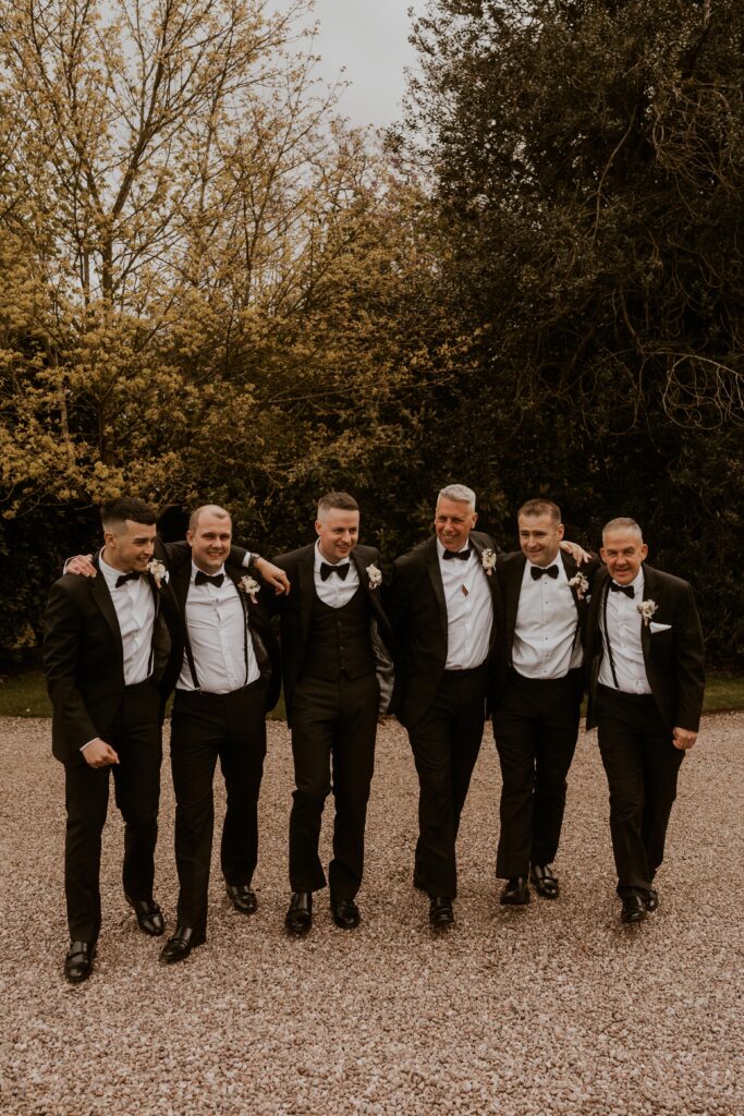 candid group photo of groomsmen in black wedding party at davenport house