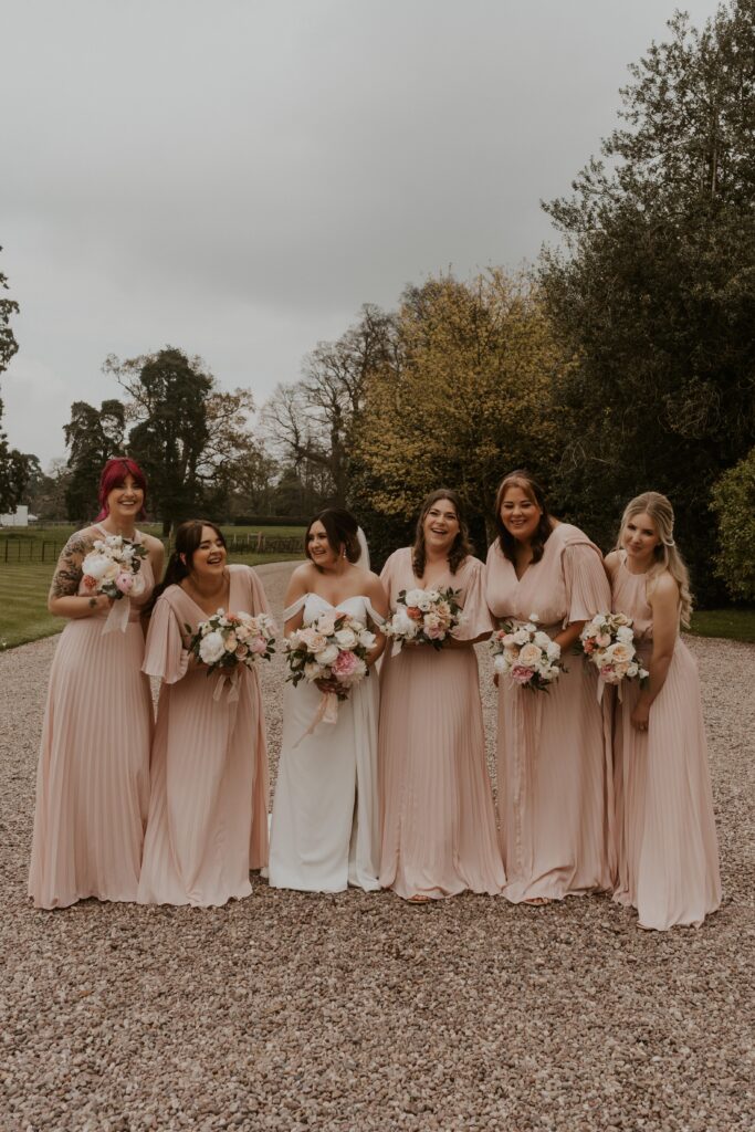 candid group photo of bridesmaid in blush pink dresses at davenport house