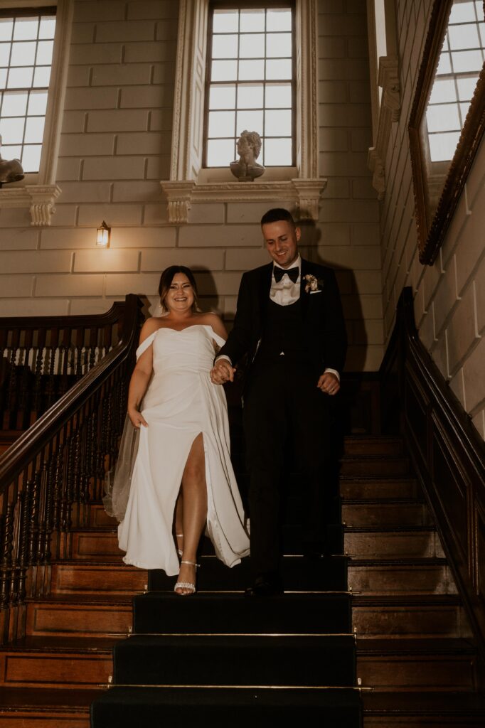 arty flash photography of fun couple coming down the stairs at davenport house
