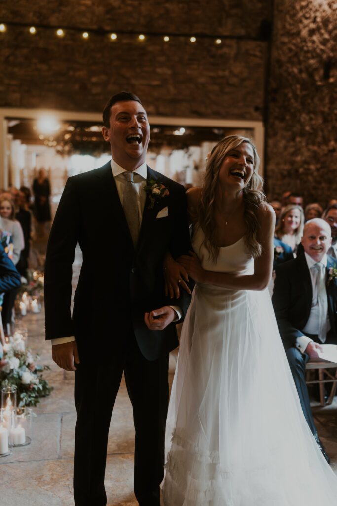 bride and groom laughing with each other as they say their marriage vows at Eden Barn Wedding venue