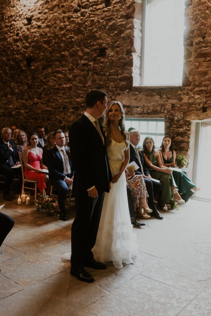 bride and groom laughing with each other as they say their marriage vows at Eden Barn Wedding venue