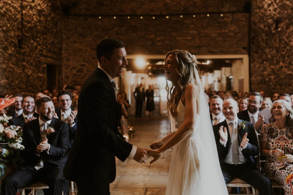 bride and groom share their first kiss in theit ceremony at Eden Barn Wedding venue