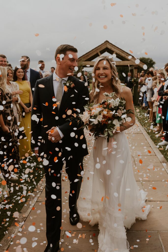 awesome colourful confetti shot with happy bride and groom at Eden barn wedding venue