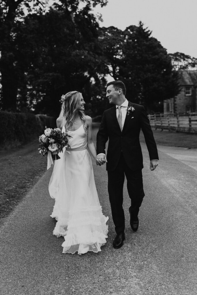 Black and white photo of Newlyweds captured in cool and creative wedding moment at eden barn wedding venue