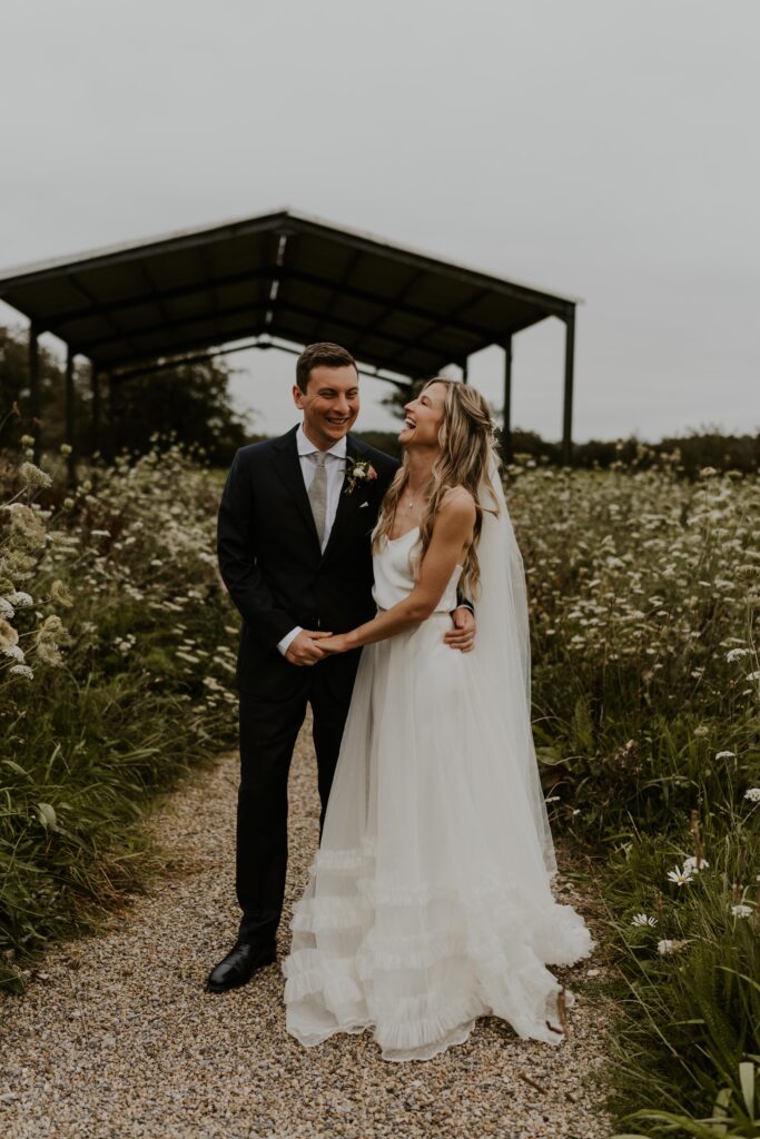 Newly married couple, adventurous and wild at heart, embarking on their next great adventure together, hand in hand at eden barn wedding venue