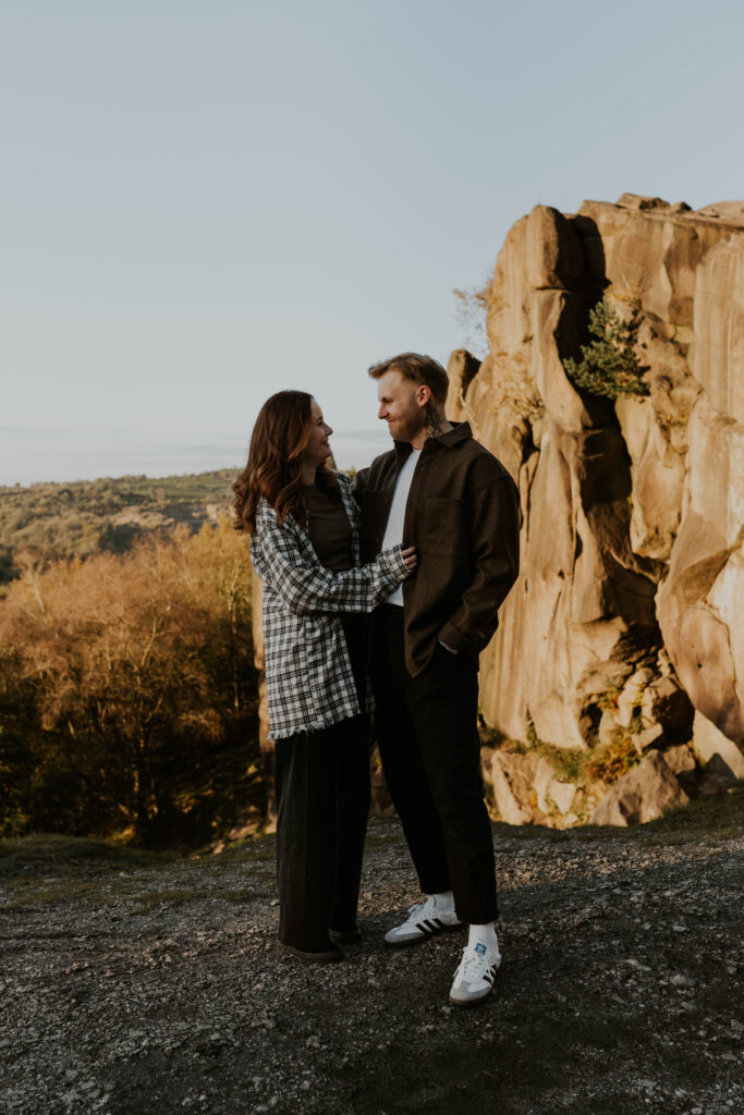relaxed wedding photographer husband and wife team capturing alternative couple at the top of a mountain with amazing views at sunset